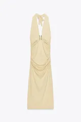 Vestido midi color crema de poliamida con cuello halter con lazada, escote pico pronunciado, detalle de pieza metálica y tejido con frunces.