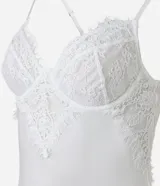 Camisón corto blanco de microfibra con breteles finos regulables y detalle de encaje floral en el busto.