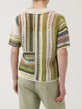 Sweater de crochet multicolor con cuello camisero, manga corta y cierre frontal con botones.