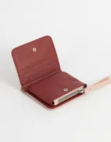 Billetera pequeña color rosa con textura símil cuero, cierre superior con cremallera y tiras de cuero sintético.