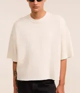 Remera oversized de algodón color crudo, con cuello redondo, manga corta, sin estampa y ribete acanalado.