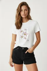 Remera blanca de algodón con estampado de flores en forma de sello postal.