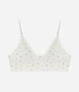 Soutien top blanco con estampado de mini flores, detalle de encaje en el escote, breteles regulables y copas desmontables.