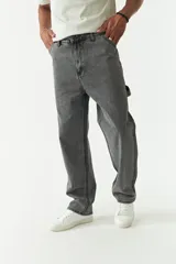 Pantalón jean celeste de corte amplio, estilo carpenter, con bolsillos laterales y logo bordado.