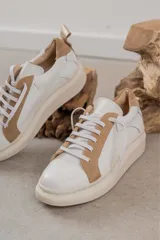 Championes urbanos blancos con detalles en cuero color tostado en la puntera, laterales y talón.