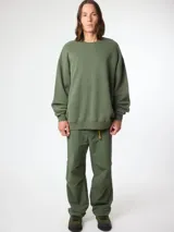 Sudadera verde militar de algodón orgánico, corte oversize, con cuello redondo y puños acanalados. Estampado en el frente y la espalda con diseño de fogata y texto 'Blue Banana'.