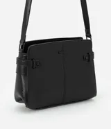 Cartera mediana negra de poliuretano con correa ajustable, cierre de cremallera y detalles texturizados.