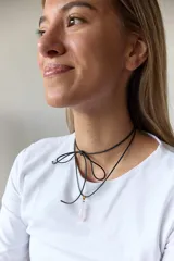 Gargantilla con tira de cuero negro y dije de piedra natural azul en forma de gota.