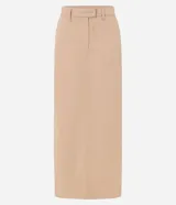 Pollera larga color beige, de tiro alto, corte recto y confeccionada en sarga ligera. Presenta trabillas en la cintura, cierre con botón y cremallera, y abertura en la parte posterior.