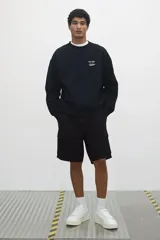 Short cargo negro de tejido grueso de algodón con cierre decorativo y cintura elástica con cordón para ajustar. Tiene bolsillos al bies y bolsillos de solapa con cierre autoadherente en las piernas y atrás. Corte estándar para una silueta clásica y cómoda.