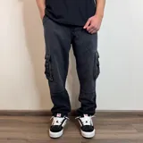Pantalón jean cargo gris oscuro, corte holgado, con bolsillos laterales y traseros.
