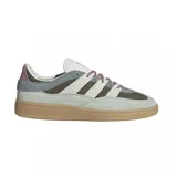 Zapatillas Adidas Handball Spezial ST en tonos gris, verde oliva y blanco. Confeccionadas en gamuza y material textil, con las tres tiras laterales en blanco y suela de goma color caramelo.