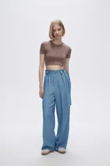 Pantalón celeste de tiro alto, corte ancho y lazo en la cintura.