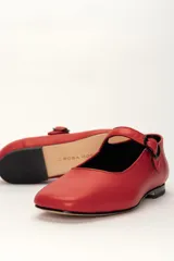 Zapato estilo Mary Jane color marrón, de cuero, con punta redondeada y tira sobre el empeine con hebilla.