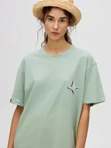 Remera amarilla de corte cuadrado y holgado, con estampado de estrella plateada con borde negro en el frente.