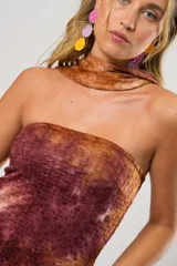 Vestido largo marrón con estampado batik, escote recto, tajo lateral y lazo para atar al cuello.