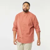 Camisa de manga larga color salmón con cuello mao y bolsillo en el pecho.