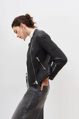 Campera negra de cuero ovino con cierre frontal asimétrico, cuello mao con botón a presión y bolsillos con cierre.