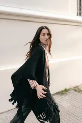 Ruana tejida en lana merino color amarillo pastel, con terminación de flecos.