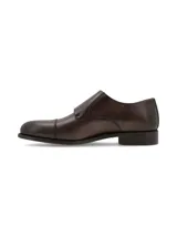 Zapato de vestir marrón oscuro, estilo monk strap, con doble hebilla plateada y puntera redondeada.