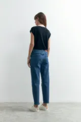 Jean mom de tiro alto, color azul medio, con corte a la altura del tobillo y terminación desflecada.