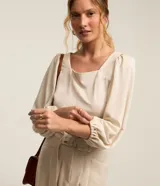 Blusa color beige confeccionada en viscosa, con escote cuadrado, mangas largas abullonadas y puños ajustados.