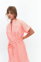 Vestido corto color coral con estampado de flores pequeñas, cuello mao y escote en V.