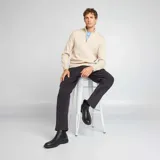 Sweater de punto color beige con cremallera en el cuello y corte clásico.