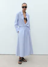 Falda larga color celeste claro, de tejido de algodón, con cintura elástica ajustable mediante cordón y bolsillos laterales.