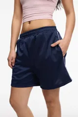 Short deportivo color bordó de tela satinada con cintura elastizada, bolsillos laterales y franja lateral blanca.