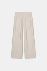 Pantalón ancho color beige de tiro alto con cintura elástica y bolsillos delanteros.