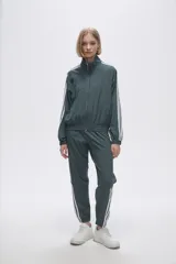 Campera deportiva verde con cierre frontal, cuello alto y tres rayas blancas en las mangas.