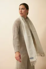 Bufanda unisex con flecos, confeccionada en lana fina sin teñir, con diseño pata de gallo en tonos beige y marrón.