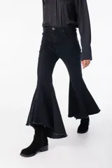 Pantalón de jean elastizado negro con corte acampanado y volados en el ruedo.