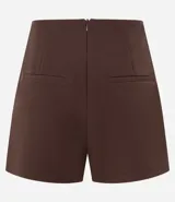 Short pollera corto de sastrería en color bordó, con diseño cruzado de borde redondeado y cierre de cremallera en la parte posterior.