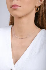 Collar corto con cadena dorada y pequeñas cuentas facetadas de color rosa pastel.