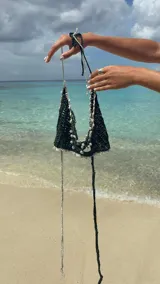 Top tejido a crochet color negro, con terminaciones en crochet color gris y tiras con perlas.