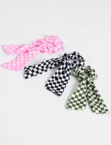 Set de tres gomitas para el pelo con lazo, con estampado a cuadros en colores rosa, blanco y negro, y verde y blanco.