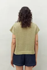 Chaleco tejido color crudo con diseño calado, cuello redondo y mangas cortas. Corte holgado.