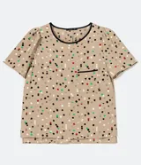 Blusa de crepé color beige con estampado de lunares de colores, cuello redondo con ribete negro, manga corta abullonada, bolsillo de parche en el pecho y bajo mullet con aberturas laterales.