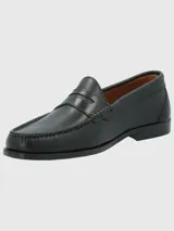 Zapato mocasín de cuero color marrón, con detalle de antifaz y suela de cuero y goma.