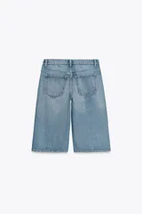 Bermudas de jean celeste de tiro bajo, con bolsillos delanteros y traseros, pinzas delanteras y cierre frontal con cremallera y botón metálico.