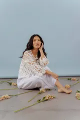 Blusa beige de hilo calado con mangas largas y cuello redondo.