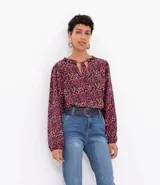 Blusa ancha de viscosa con cuello mao y mangas largas con puños elásticos. Estampado de flores en tonos borgoña y negro.