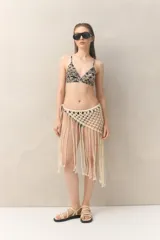 Top de bikini con estampado botánico en tonos negro y beige, de corte triangular fijo con tirantes finos.