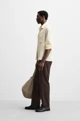 Pantalón marrón de pana, corte recto, con bolsillos laterales y traseros.