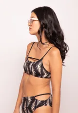 Top de bikini negro con estampado de hojas color beige, breteles finos fijos y gancho en la espalda. Con forro y copas desmontables.
