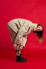 Pantalón de gabardina elástica color beige, estilo cargo/bombacha de gaucho, con bolsillos grandes y tobillos ajustables con tiras de cuero gamuzado.