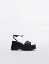 Sandalias negras con plataforma y tiras finas.