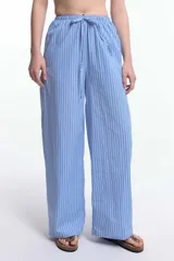 Pantalón de pijama celeste a rayas verticales blancas, de corte ancho y cintura elástica con cordón ajustable.